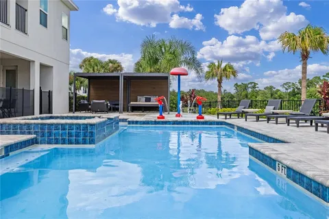 Resort pool with splash features, spa, and outdoor seating